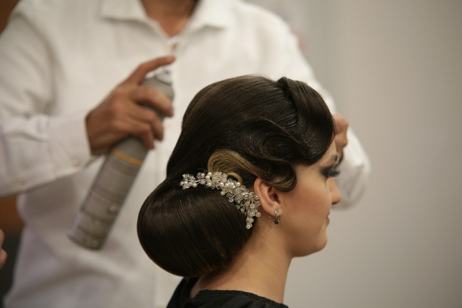 A sleek bridal bun being finished